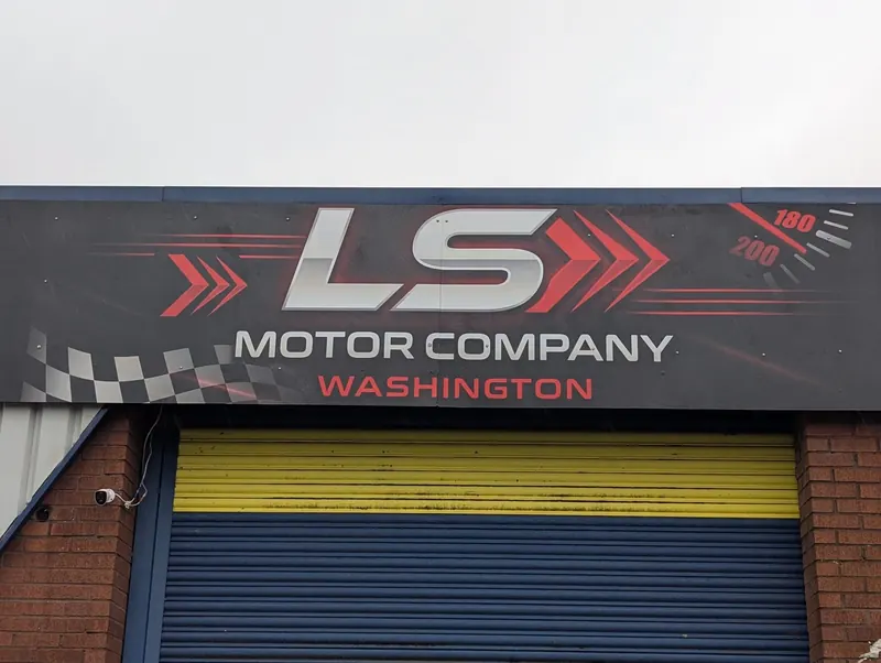 ACM fascia sign for LS Motor Company above a roller shutter in Washington