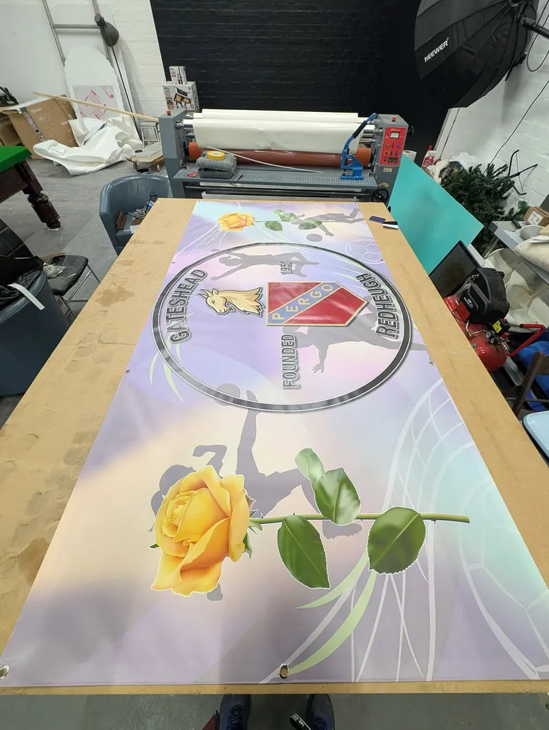 Gateshead Redheugh club banner on the finishing table with eyelets fitted