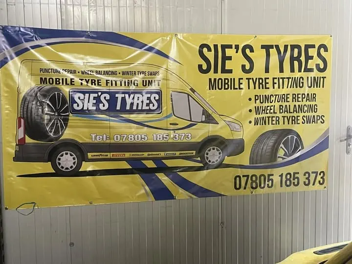 Yellow PVC banner for Sie's Tyres mobile tyre fitting, fixed to a wall