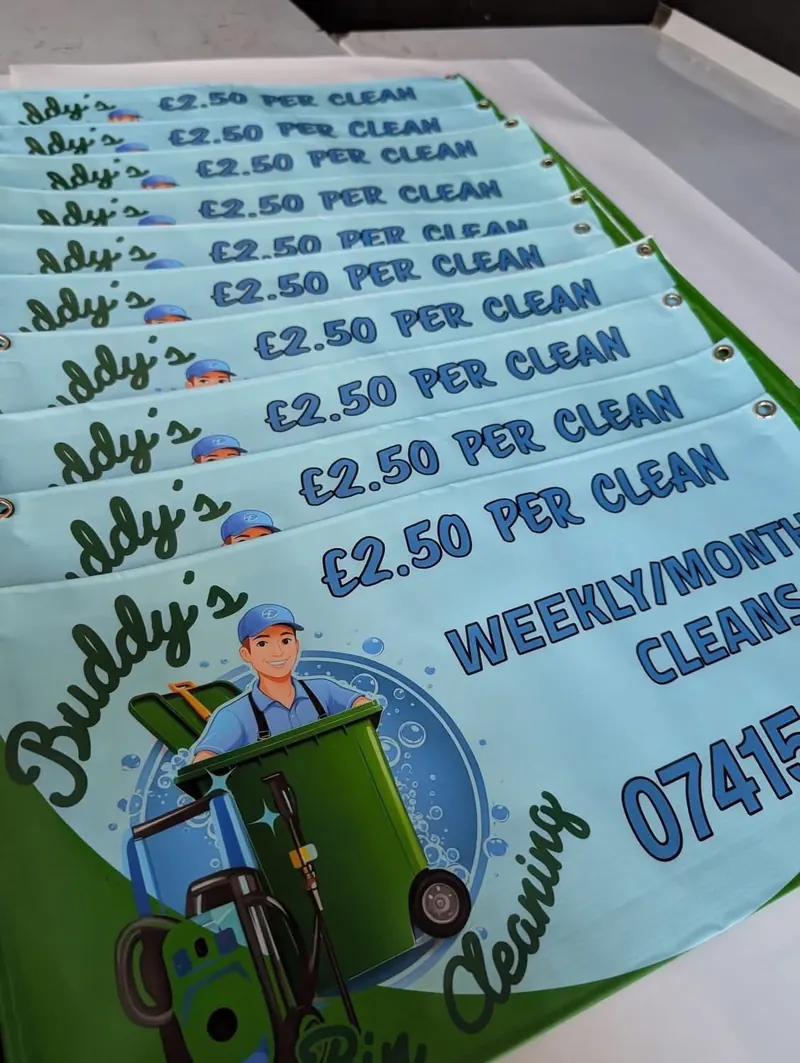 A stack of finished, eyeleted banners for Buddy's bin cleaning