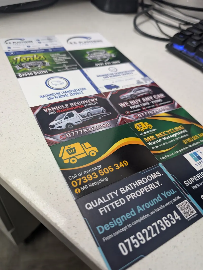 Printed flyers and business cards for local businesses laid out on a desk